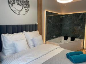 a bedroom with a bed and a bath tub at Caroline Jacuzzi Apartments in Nowy Dwór Mazowiecki