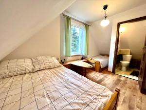 Un dormitorio con una cama grande y una ventana en Fantastyczny domek 5-min od jeziora Łukcze, en Rogoźno