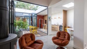 a living room with two chairs and a kitchen at Maison-Loft de standing autour de son patio in Vannes