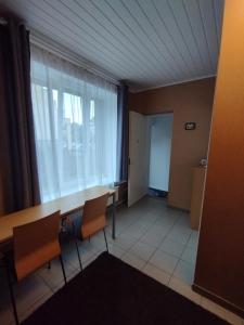 um quarto com uma mesa e cadeiras e uma janela em Room for 2 em Šiauliai