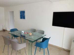 a dining room with a glass table and chairs at Blonay Garden Apartment - Swiss Hotel Apartments in Blonay