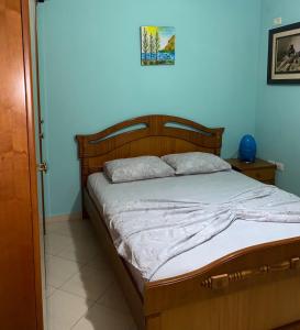 1 cama en un dormitorio con una pared azul en Tirana’s Elevated Apartment en Tirana