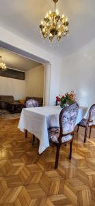 a dining room with a table and chairs and a chandelier at Gelahouse in Batumi