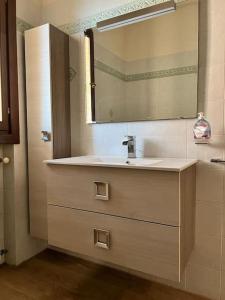 a bathroom with a sink and a mirror at Appartamento Altopascio sulla Francigena in Spianate +12 photos