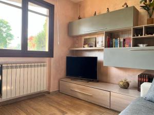 a living room with a flat screen tv on a cabinet at Appartamento Altopascio sulla Francigena in Spianate
