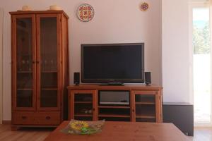 a television sitting on a wooden stand in a living room at Cabo de Gata - Playa y Golf - Retamar El Toyo in El Toyo