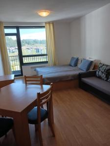 um quarto com uma cama, uma mesa e um sofá em Аспен валей С420 em Razlog