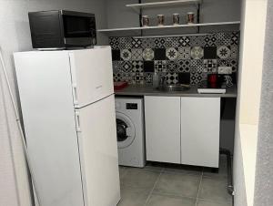 cocina con nevera y lavadora en Langeais - Gîte des Culeveaux, en Langeais