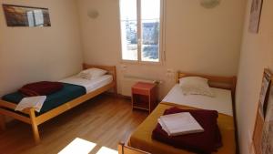 two beds in a small room with a window at APF France handicap - Ferme Léonie in Saint-Laurent-en-Grandvaux