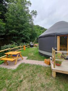 stół piknikowy i namiot na dziedzińcu w obiekcie Yourte des Verts Bois w mieście Fréland