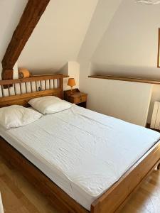 1 dormitorio con 1 cama grande con sábanas blancas en Spacieux appartement pour 6 en Guérande