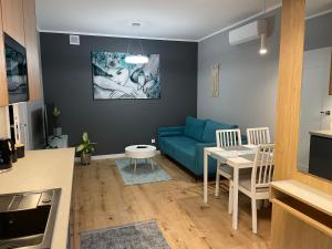 a living room with a blue couch and a table at Caroline Jacuzzi Apartments in Nowy Dwór Mazowiecki