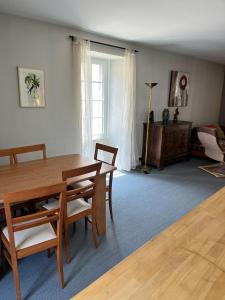sala de estar con mesa de madera y sillas en Spacieux appartement pour 6 en Guérande