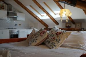 una camera da letto con letto, lenzuola e cuscini bianchi di Appartamento Les Cimes a Bardonecchia