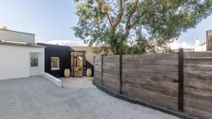 uma cerca de madeira em frente a uma casa em Maison-Loft de standing autour de son patio em Vannes