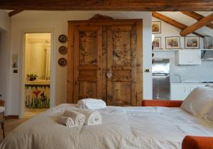 una camera da letto con un letto bianco e asciugamani di Appartamento Les Cimes a Bardonecchia