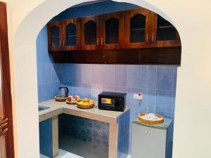 a kitchen with a counter with a microwave at KorKoCove Beachfront Suites in Accra