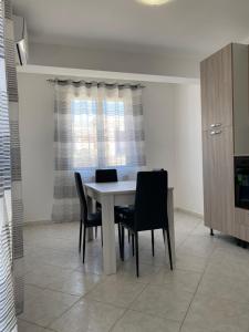 a dining room with a table and chairs and a window at [la terrazza del sole] in Menfi