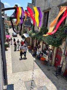 un grupo de personas caminando por una calle con banderas en Spacieux appartement pour 6 en Guérande