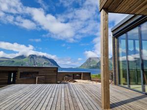 a house with a deck with a view of the water at Classy Cabin Lofoten in Kleppstad
