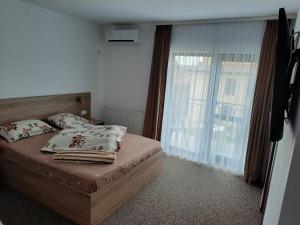 1 dormitorio con cama y ventana grande en king, en Băile Felix