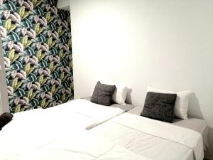 2 camas en una habitación con papel pintado floral en La MARINA en Alicante