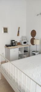 a white kitchen with a white bed in a room at Neaktion Apartments in Nikiti