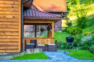 a grill in a yard next to a house at Domek Góralski in Piwniczna-Zdrój