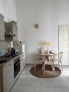 una cucina con tavolo, tavolo e sedie di Zephir Suite a Brindisi