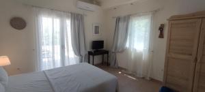 a bedroom with a bed and two large windows at Neaktion Apartments in Nikiti