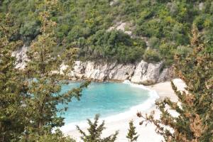 a view of a beach with blue water and trees at Sissy Villas 2 in Poros Lefkadas