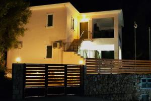 a white house with a fence in front of it at Sissy Villas 2 in Poros Lefkadas