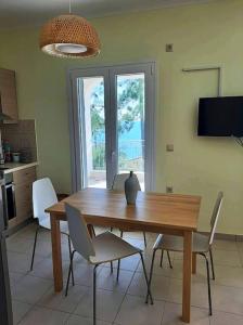 een houten tafel en stoelen in een keuken met een eetkamer bij Sissy Villas 2 in Poros