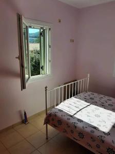 een slaapkamer met een bed en een raam bij Sissy Villas 2 in Poros