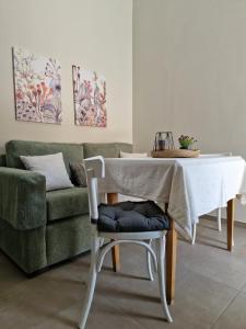 un tavolo e una sedia con un tavolo e un divano di The Garden House a Città di Tinos