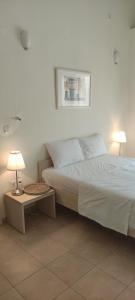 a bedroom with a bed and two lamps on tables at Neaktion Apartments in Nikiti