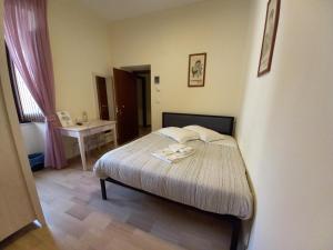 a small bedroom with a bed and a table at L'Antico Monastero in SantʼAgata di Puglia