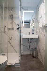 uma casa de banho com um chuveiro, um lavatório e um WC. em Hotel & Restaurant Knote em Sindelfingen