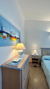 1 dormitorio con 1 cama y 1 mesa con lámpara en VILLA FRANCESCA, en Tanaunella
