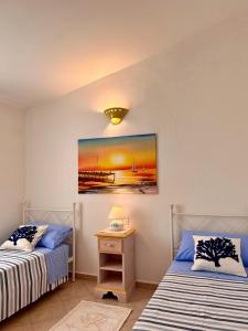 um quarto com 2 camas e uma mesa com um candeeiro em VILLA FRANCESCA em Tanaunella