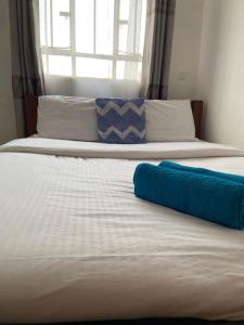 Comfy One Bedroom Apartment at Joyland Ruaka في Ruaka: سرير عليه وسادة زرقاء