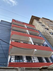 Comfy One Bedroom Apartment at Joyland Ruaka في Ruaka: مبنى طويل وبه اللون الأحمر والأبيض