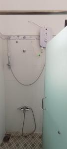 a bathroom with a shower with a hose on the wall at Villa mặt biển - bờ kè Đông Hải in Ninh Hòa