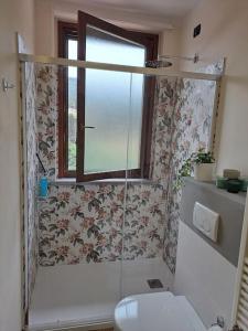 een badkamer met een douche, een toilet en een raam bij The Green House in Troghi in Troghi