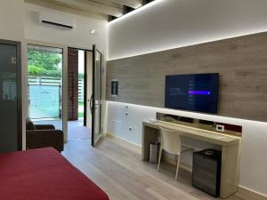 a bedroom with a desk and a tv on a wall at Luna Residence Hotel in Casalmaggiore