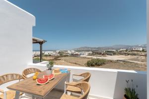 a dining table and chairs on a balcony with a view at Caruana Inland Naxos in Agia Anna Naxos