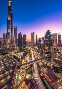 um horizonte da cidade à noite com trânsito em Fashion Avenue Dubai Mall no Dubai