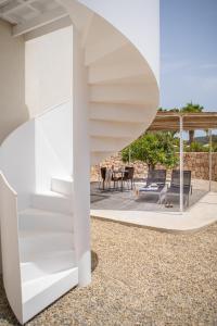 a white house with a spiral staircase and a patio at Can Jaume Private Villas by Ocean Drive in Ibiza Town