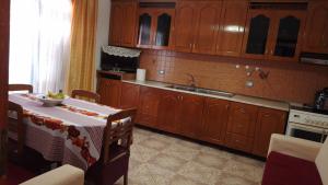 a kitchen with wooden cabinets and a table and a sink at House in Vlorë