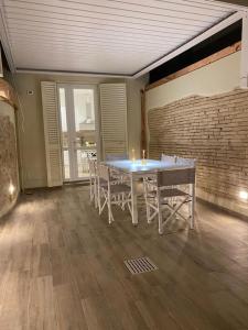 d'une salle à manger avec une table, des chaises et un mur en briques. dans l'établissement 70mt dal mare, à Viareggio